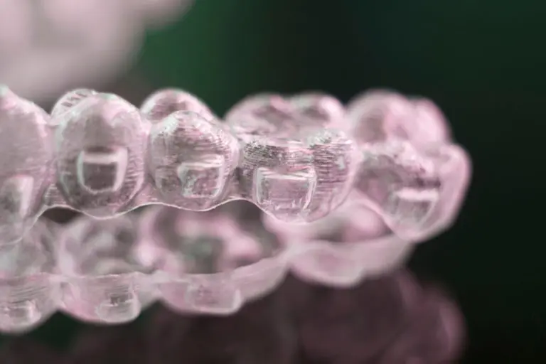 A clear dental aligner tray showing detailed tooth impressions rests on a reflective surface—patients at Andros Orthodontics in Pasco, WA appreciate Invisalign for its discreet look and comfortable fit.