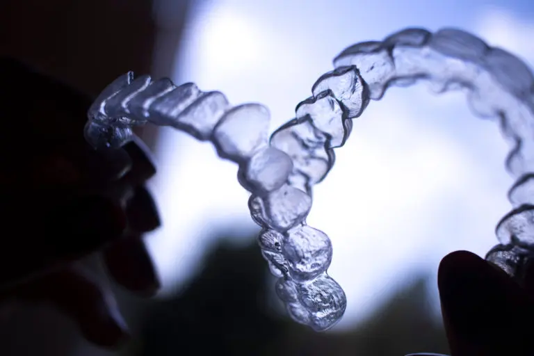 Clear dental aligners used for Invisalign are shown against a light background at Andros Orthodontics in Pasco, WA, emphasizing their translucent material and contoured design.