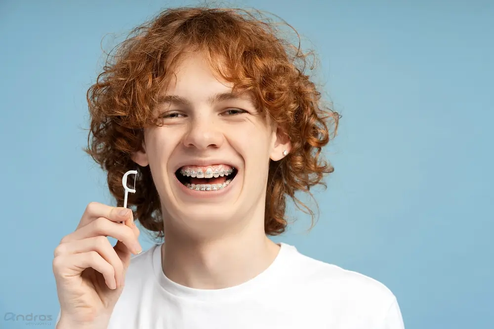 close up image smiling teenager curly red hair metal braces - How to Floss with Braces in Pasco, WA.
