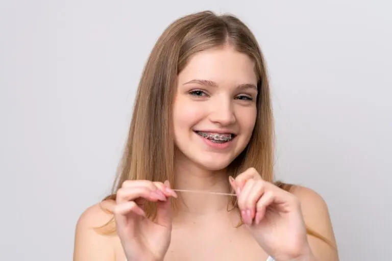 teenager russian girl with metal braces and floss isolated white background - How to Floss with Braces in Pasco, WA.
