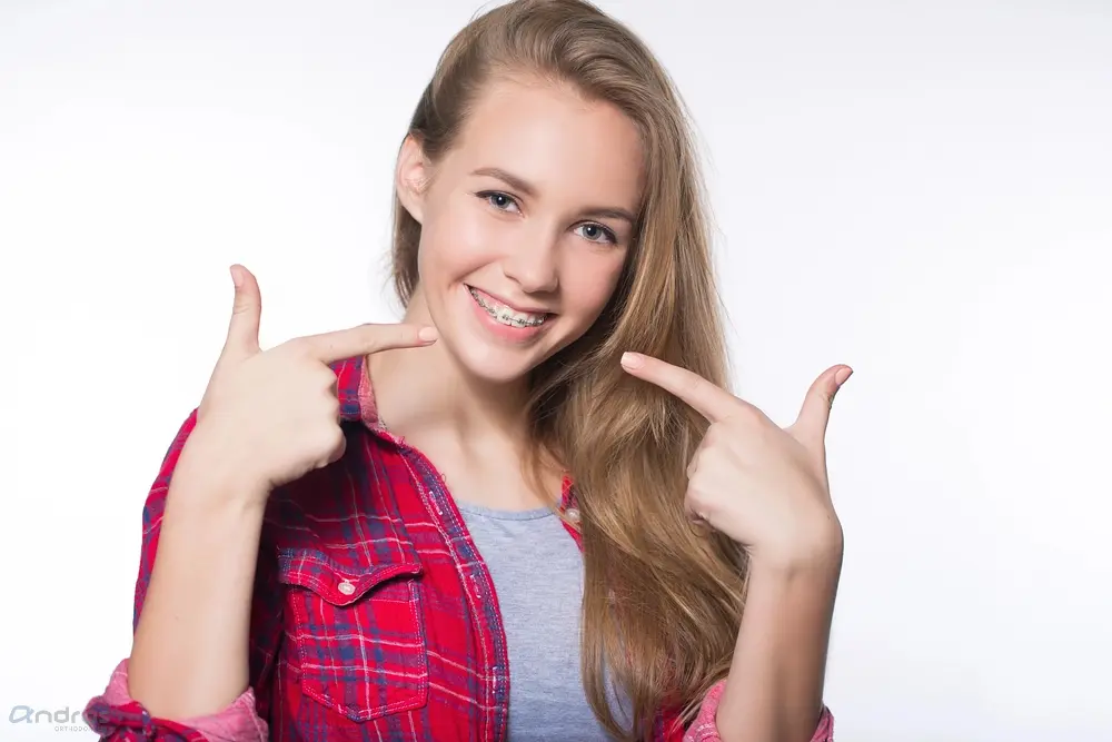 beautiful young blondie girl showing her metal braces isolated white - How to Get Braces Glue Off Teeth in Pasco, WA