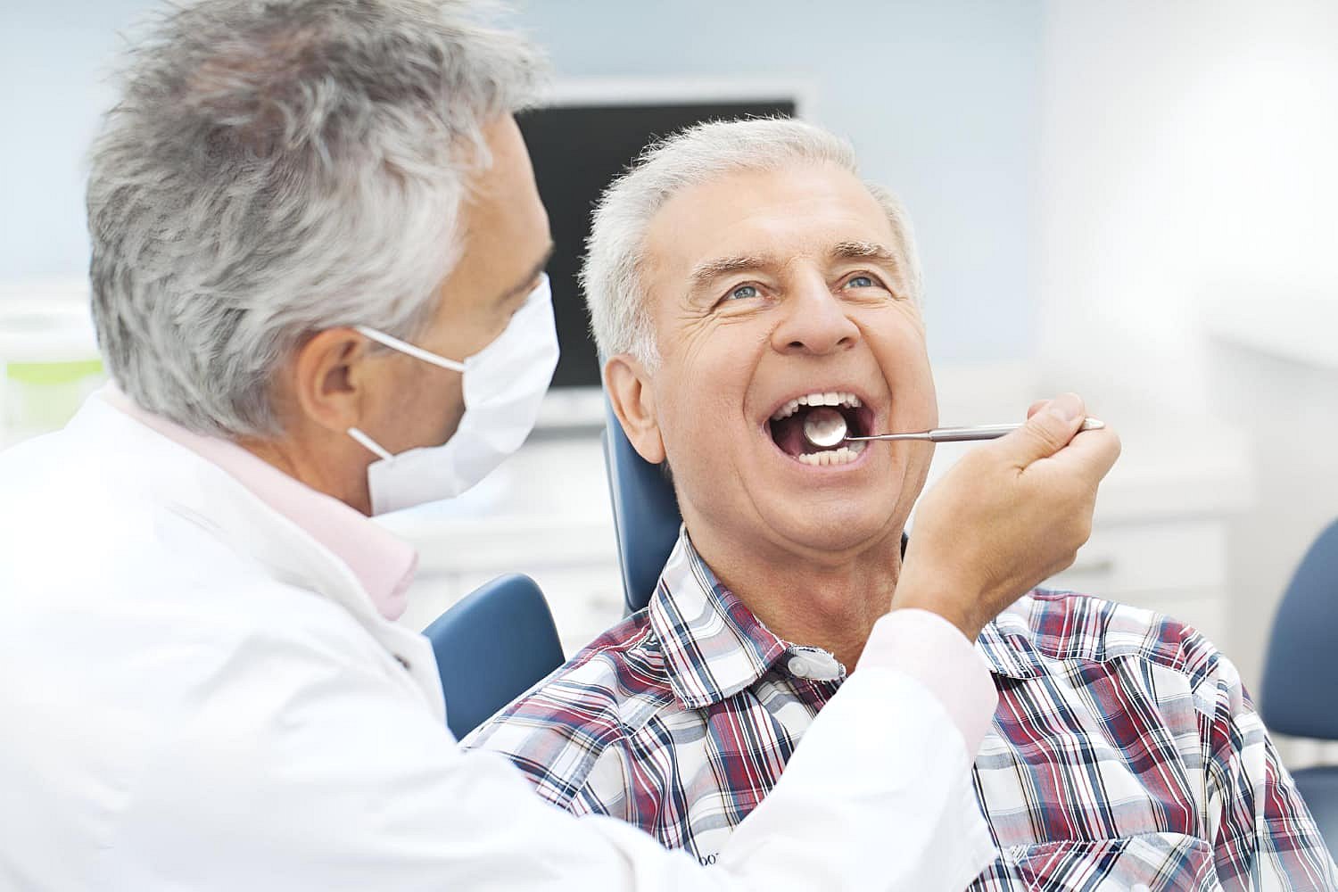 At Andros Orthodontics in Pasco, WA, a dentist examines an older male patient’s open mouth to assess him for possible jaw surgery.