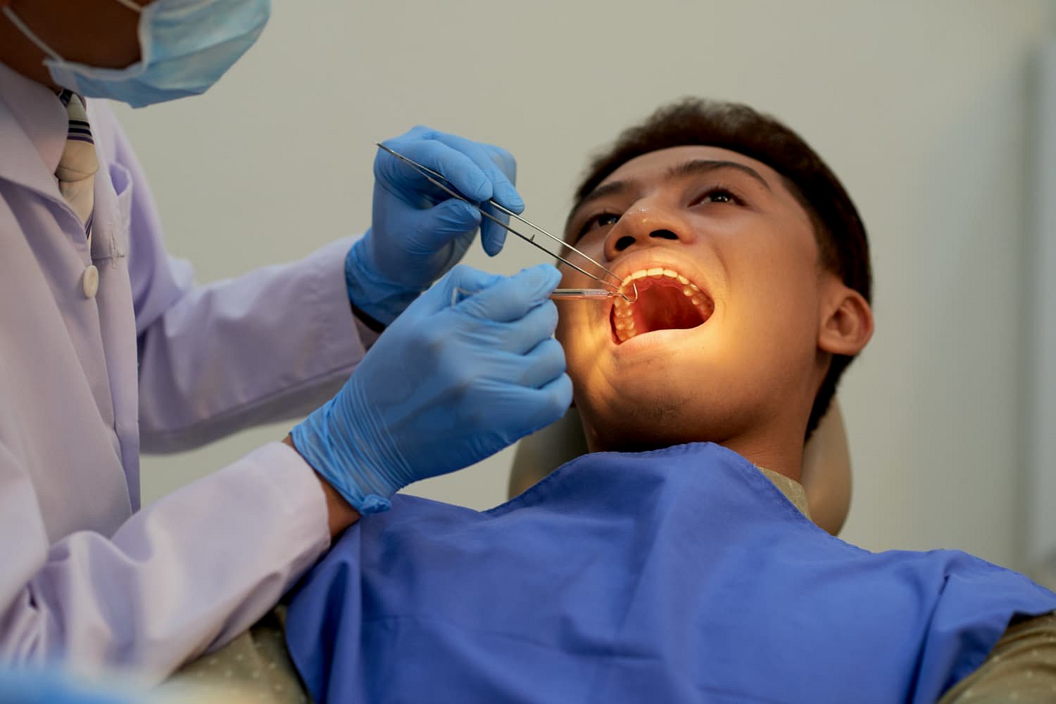At Andros Orthodontics in Pasco, WA, a dentist uses dental instruments to examine a patient’s open mouth for issues such as an underbite.